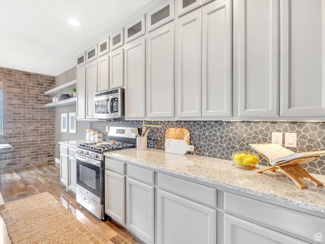 2813 W Hidden Moose Ln, Lehi, UT 84043 - kitchen with appliances with stainless steel finishes, open shelves, backsplash, and light wood-type flooring