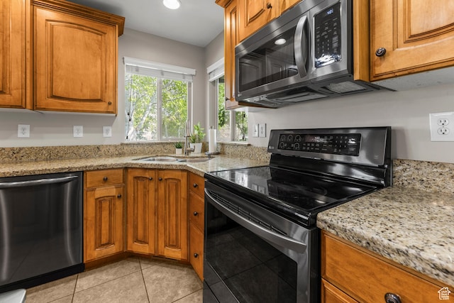 454 N 3550 W, Layton, UT 84041 - kitchen featuring appliances with stainless steel finishes, brown cabinets, light tile patterned flooring, light stone countertops, and recessed lighting