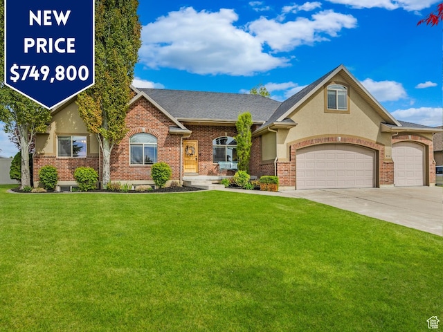 454 N 3550 W, Layton, UT 84041 - view of front of house with a front lawn, driveway, an attached garage, stucco siding, and brick siding