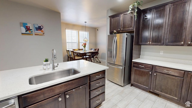 10627 S Lake Terrace Ave S, South Jordan, UT 84009 - kitchen featuring stainless steel refrigerator with ice dispenser, a sink, dark brown cabinetry, decorative light fixtures, and light wood-style floors