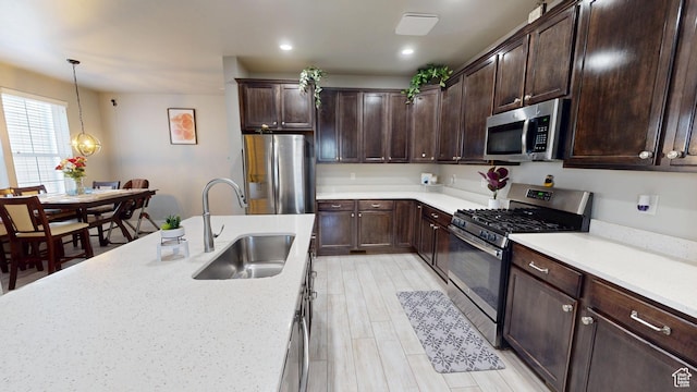 10627 S Lake Terrace Ave S, South Jordan, UT 84009 - kitchen featuring appliances with stainless steel finishes, a sink, dark brown cabinets, pendant lighting, and recessed lighting