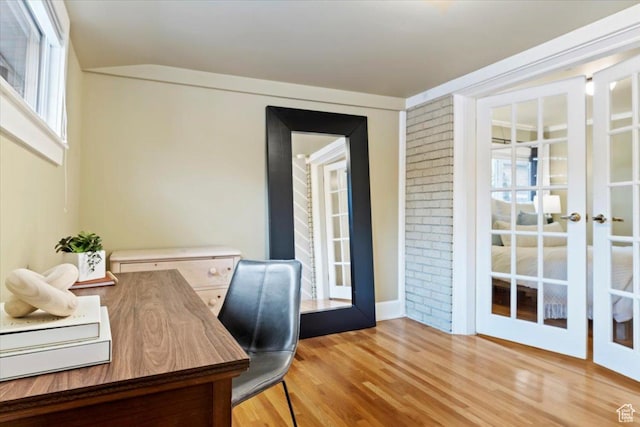 home office with french doors, lofted ceiling, and wood finished floors