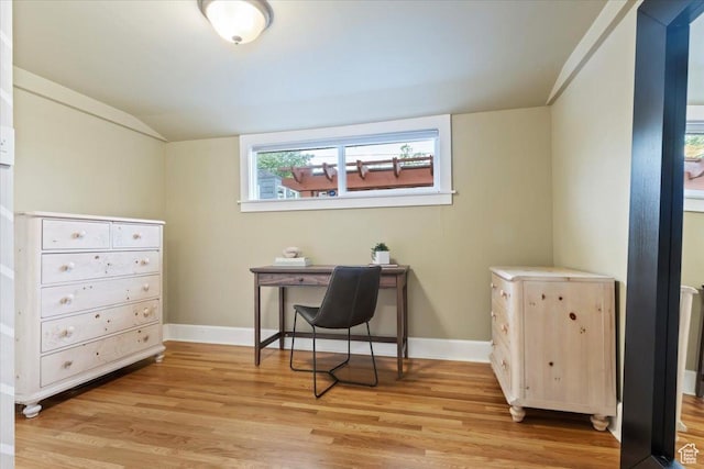 office area with baseboards, lofted ceiling, and light wood-type flooring
