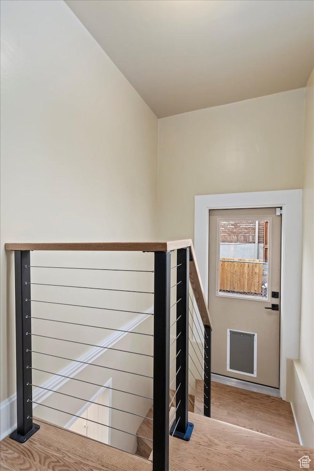 staircase with baseboards and wood finished floors