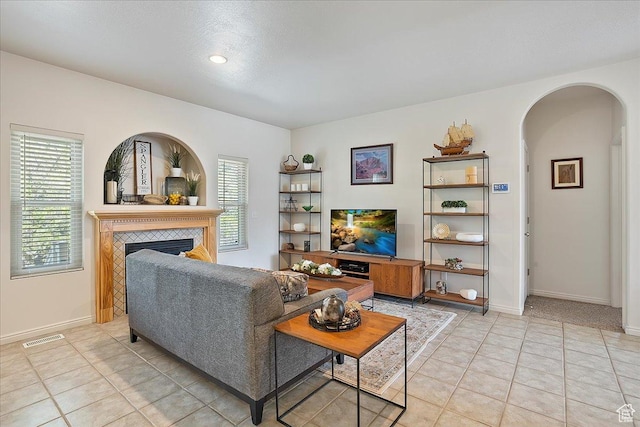 3072 S 1065 W, Syracuse, UT 84075 - living area featuring arched walkways, healthy amount of natural light, a tiled fireplace, baseboards, and recessed lighting