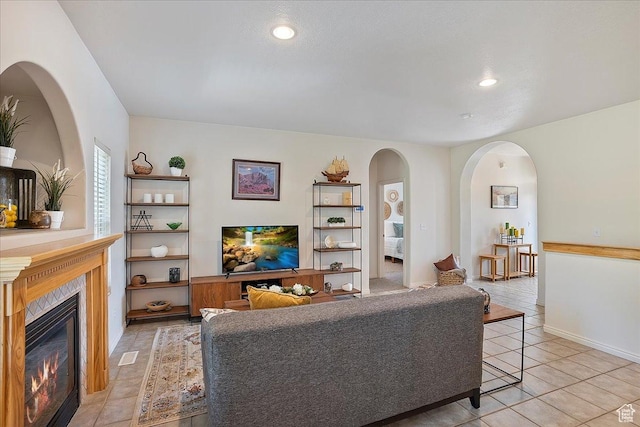 3072 S 1065 W, Syracuse, UT 84075 - living room with light tile patterned floors, a glass covered fireplace, arched walkways, and recessed lighting