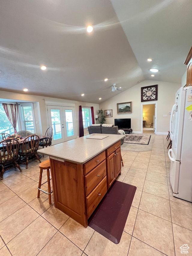1003 E 200 S, American Fork, UT 84003 - kitchen with freestanding refrigerator, light countertops, brown cabinets, lofted ceiling, and plenty of natural light