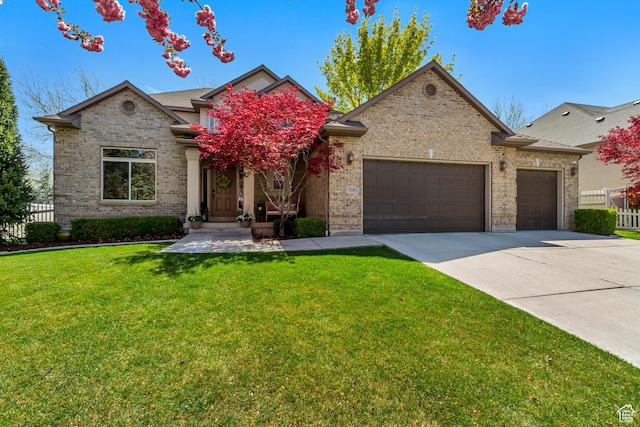 view of front of house with fence, an attached garage, brick siding, a front yard, and concrete driveway