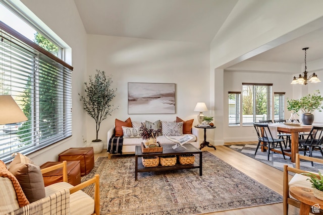 3381 W Slate View Dr, South Jordan, UT 84095 - living room with baseboards, lofted ceiling, wood finished floors, and a notable chandelier