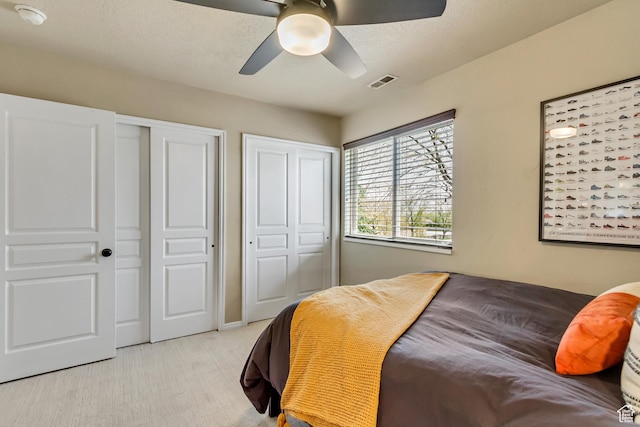 3381 W Slate View Dr, South Jordan, UT 84095 - bedroom with visible vents, multiple closets, ceiling fan, and light colored carpet