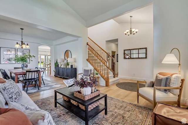 3381 W Slate View Dr, South Jordan, UT 84095 - living room featuring light wood finished floors, arched walkways, high vaulted ceiling, a chandelier, and stairway