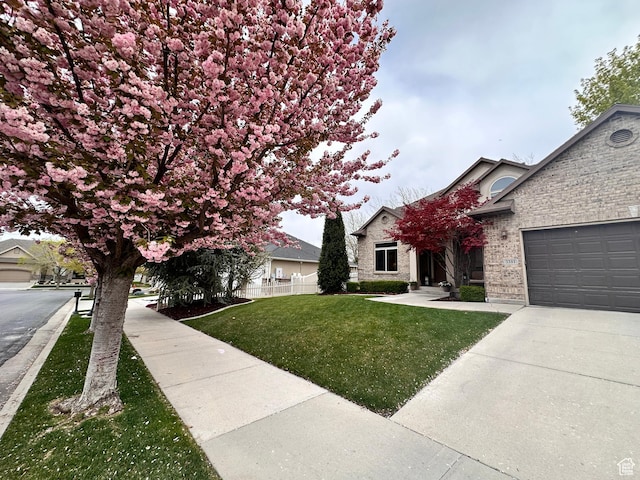3381 W Slate View Dr, South Jordan, UT 84095 - view of front of property with fence, a front yard, brick siding, concrete driveway, and an attached garage