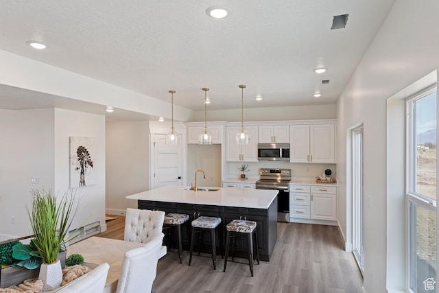 3238 S 4950 W, West Haven, UT 84401 - kitchen featuring a sink, appliances with stainless steel finishes, white cabinets, and light wood-style flooring
