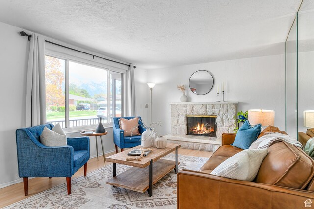 6888 S 455 E, Midvale, UT 84047 - living area featuring baseboards, a textured ceiling, wood finished floors, and a fireplace