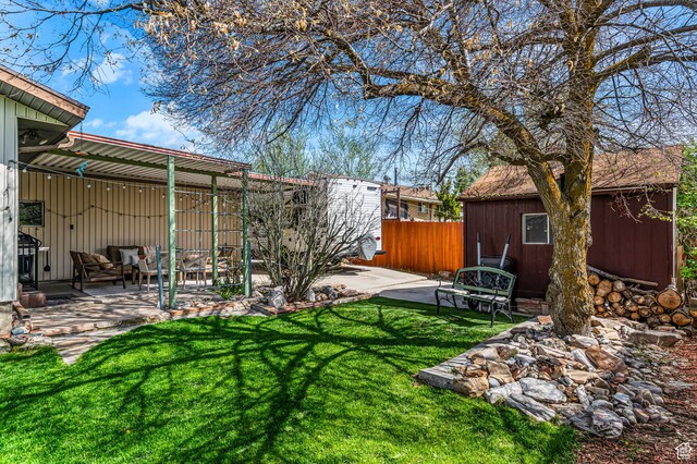 6888 S 455 E, Midvale, UT 84047 - view of yard with fence, a patio, an outdoor structure, and a storage shed