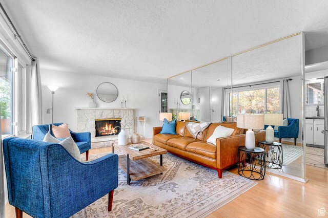 6888 S 455 E, Midvale, UT 84047 - living area with a textured ceiling, wood finished floors, and a fireplace