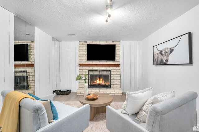 6888 S 455 E, Midvale, UT 84047 - living room with a textured ceiling, a brick fireplace, and wood finished floors