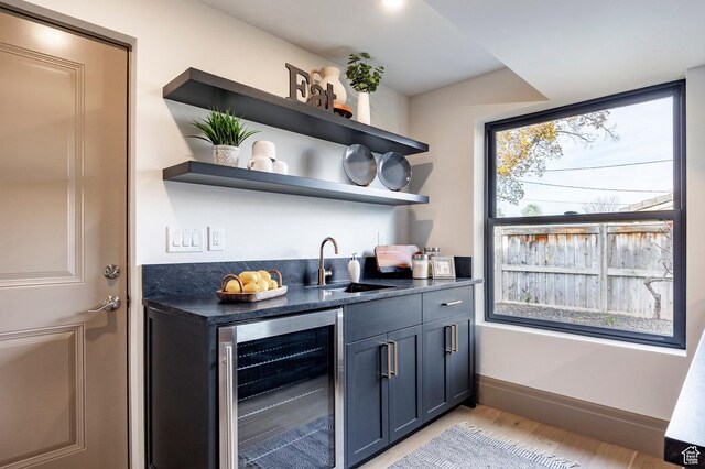2568 E Sherwood Dr, Salt Lake City, UT 84108 - bar with a sink, light wood-style flooring, indoor wet bar, baseboards, and wine cooler