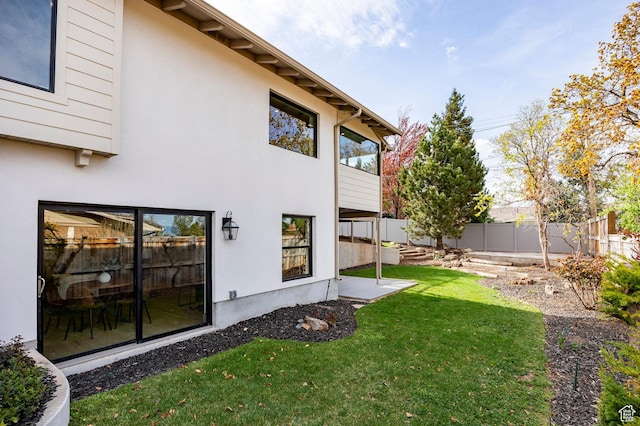 2568 E Sherwood Dr, Salt Lake City, UT 84108 - back of property featuring a lawn, a fenced backyard, and stucco siding