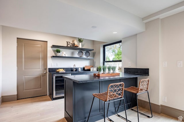2568 E Sherwood Dr, Salt Lake City, UT 84108 - bar with light wood-style floors, a sink, baseboards, indoor wet bar, and wine cooler