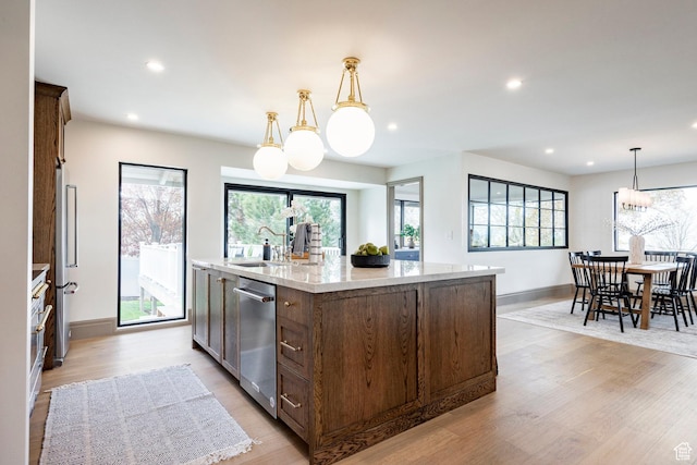 2568 E Sherwood Dr, Salt Lake City, UT 84108 - kitchen featuring appliances with stainless steel finishes, a large island with sink, light wood finished floors, and plenty of natural light