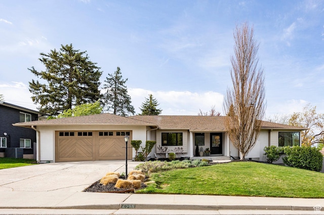 ranch-style home featuring a front lawn, an attached garage, concrete driveway, and stucco siding