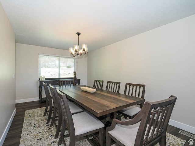 dining room with baseboards, visible vents, dark wood finished floors, and a chandelier