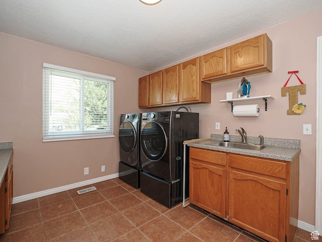 laundry room with visible vents, cabinet space, a sink, baseboards, and washer and clothes dryer