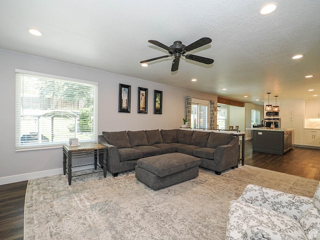 living area with recessed lighting, baseboards, dark wood finished floors, and a ceiling fan
