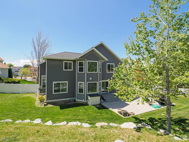 back of property featuring a lawn and fence