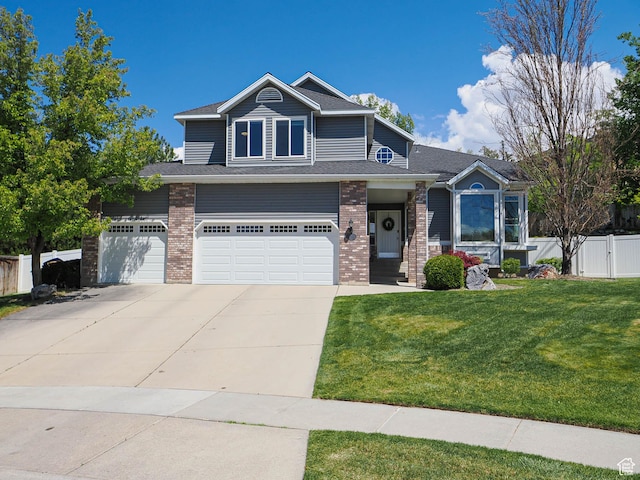 craftsman-style home featuring a front yard, brick siding, fence, concrete driveway, and an attached garage