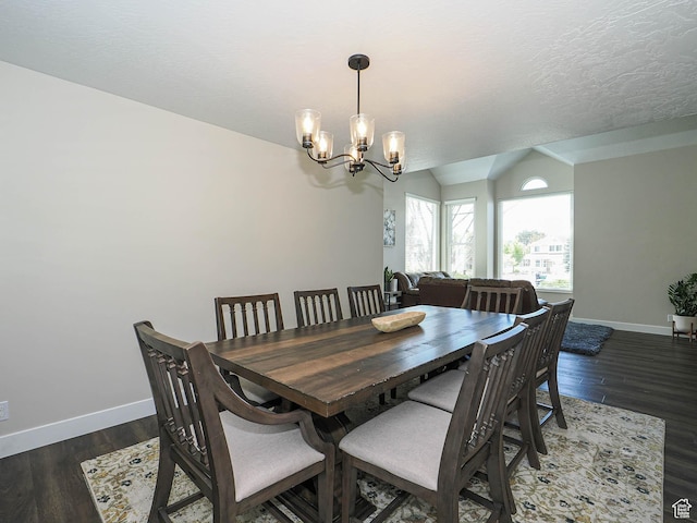 dining room with baseboards, vaulted ceiling, wood finished floors, and a chandelier