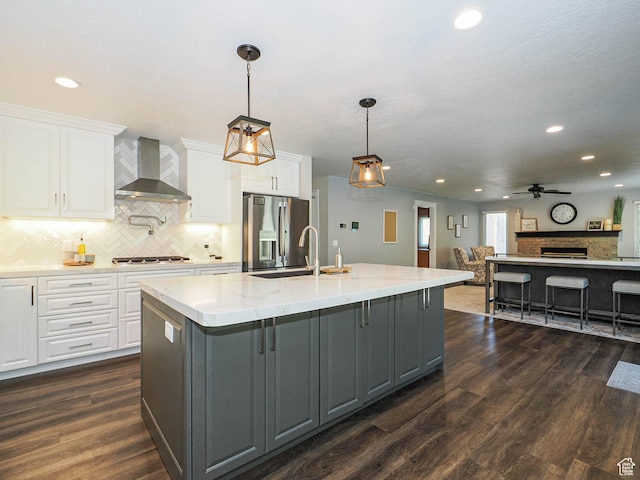kitchen with wall chimney exhaust hood, stainless steel appliances, a ceiling fan, recessed lighting, and gray cabinetry