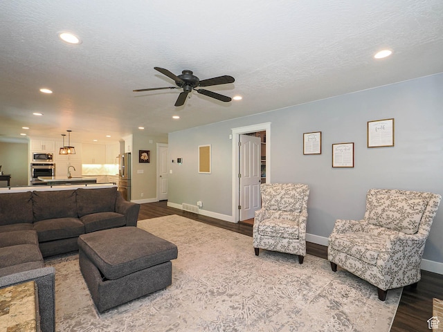 living room featuring recessed lighting, a ceiling fan, and wood finished floors