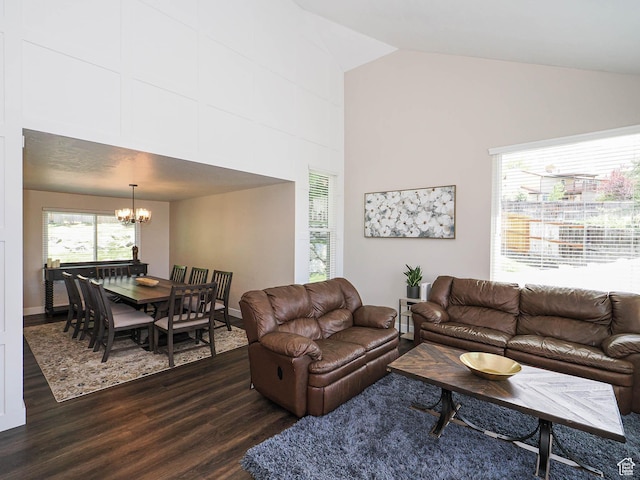 living area with dark wood-type flooring, baseboards, high vaulted ceiling, and an inviting chandelier