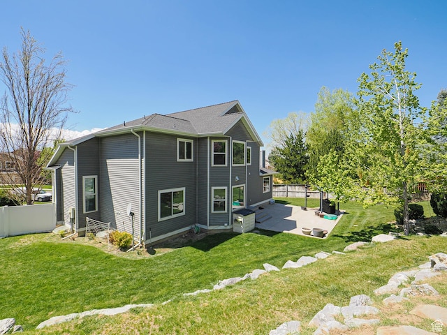 rear view of house featuring a patio area, fence, and a yard