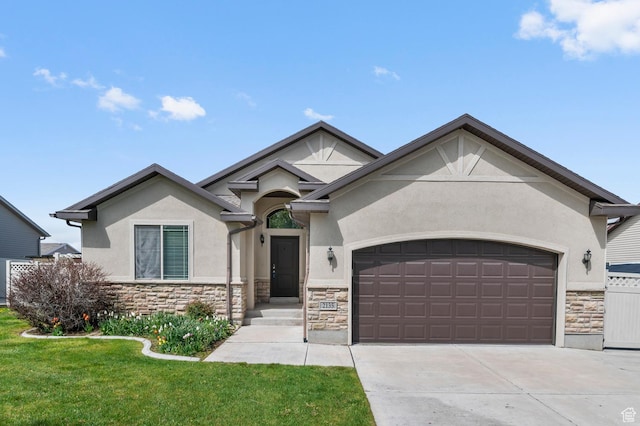 2135 N 130 W, Tooele, UT 84074 - view of front of home with an attached garage, a front lawn, stucco siding, and stone siding