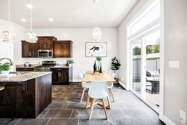 590 S 1030 E, Smithfield, UT 84335 - kitchen with a breakfast bar area, pendant lighting, dark brown cabinets, a sink, and stainless steel appliances