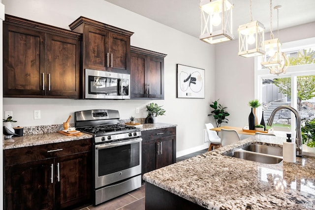 590 S 1030 E, Smithfield, UT 84335 - kitchen featuring appliances with stainless steel finishes, dark brown cabinets, a sink, light stone counters, and an inviting chandelier