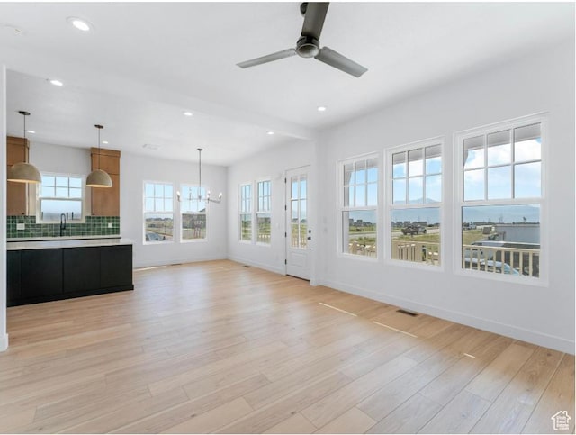 11436 S Watercourse Rd Unit 110, South Jordan, UT 84009 - unfurnished living room featuring a sink, baseboards, ceiling fan with notable chandelier, light wood-style floors, and recessed lighting