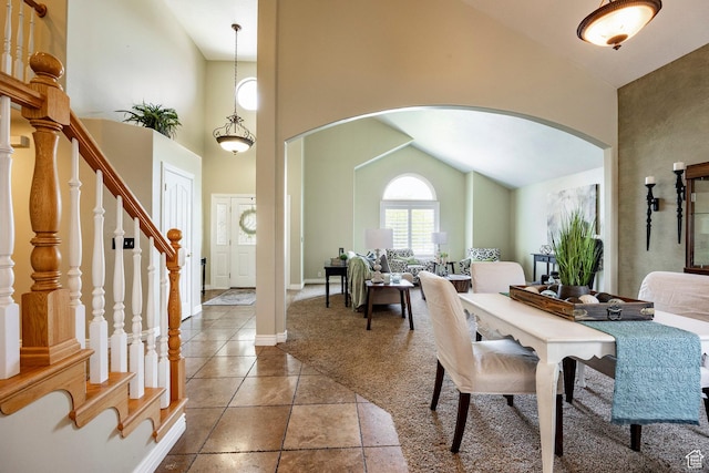 10944 S Surrey Meadow Cv, South Jordan, UT 84095 - tiled dining room featuring arched walkways, high vaulted ceiling, carpet floors, stairway, and baseboards