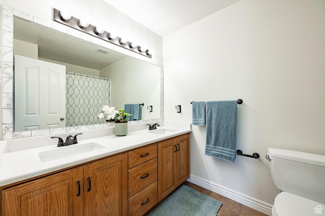 10944 S Surrey Meadow Cv, South Jordan, UT 84095 - full bath featuring double vanity, toilet, baseboards, and tile patterned flooring