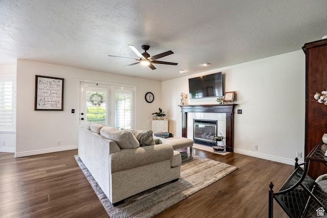 10944 S Surrey Meadow Cv, South Jordan, UT 84095 - living room featuring a textured ceiling, baseboards, dark wood finished floors, ceiling fan, and a tile fireplace
