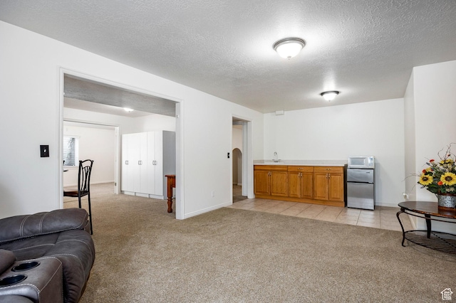10944 S Surrey Meadow Cv, South Jordan, UT 84095 - living room featuring light carpet, a textured ceiling, baseboards, and arched walkways