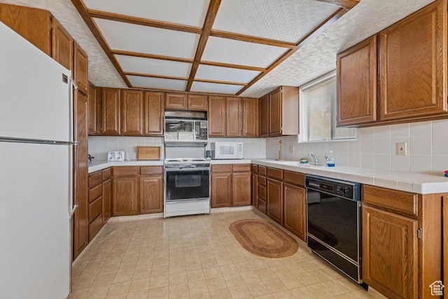 375 Hillcrest, Central, UT 84722 - kitchen featuring tile counters, brown cabinetry, backsplash, and white appliances