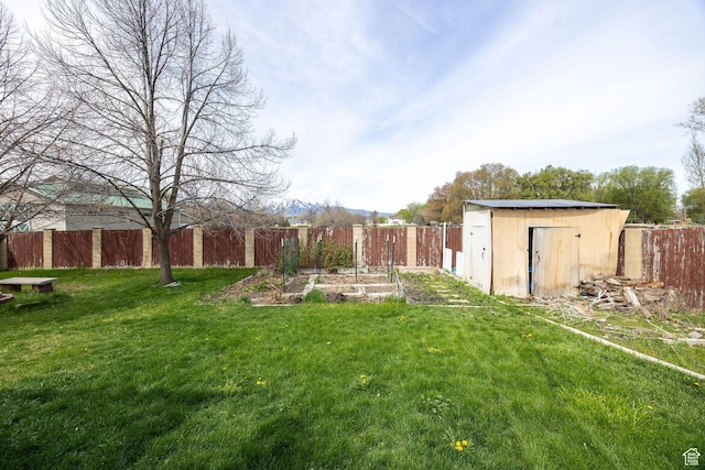 811 S Park Ave W, Logan, UT 84321 - view of yard with a storage unit, a fenced backyard, an outbuilding, and a vegetable garden