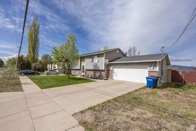 811 S Park Ave W, Logan, UT 84321 - view of front facade with fence, an attached garage, brick siding, a front yard, and driveway