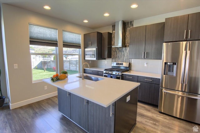 3159 N 1100 W, Pleasant View, UT 84414 - kitchen featuring appliances with stainless steel finishes, a sink, light countertops, wall chimney exhaust hood, and a center island with sink
