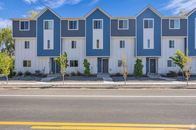 townhome / multi-family property featuring board and batten siding and central AC unit