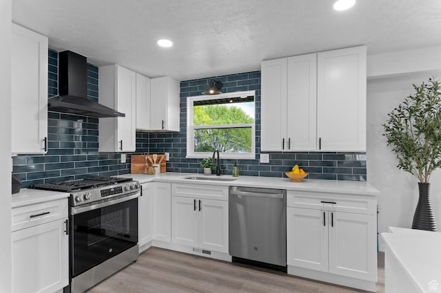 8671 S 3780 W, West Jordan, UT 84088 - kitchen featuring wall chimney range hood, appliances with stainless steel finishes, a sink, and light countertops